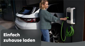 Dekoratives Bild. Eine Frau mit blondem Schulterlangen Haarschnitt schließt ihr parkendes Elektrofahrzeug an einer Elektro-Ladestation an.